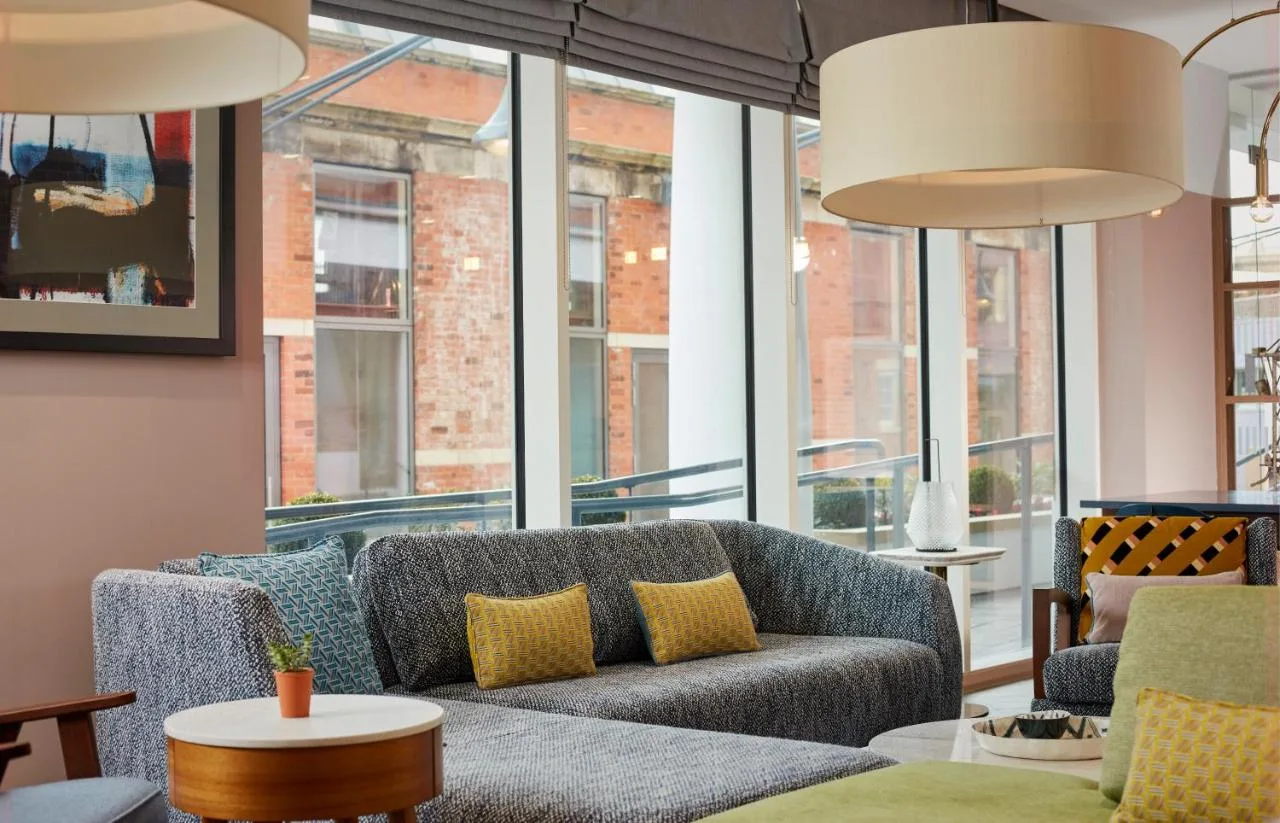 a living room with a couch and windows at Citadines Islington London