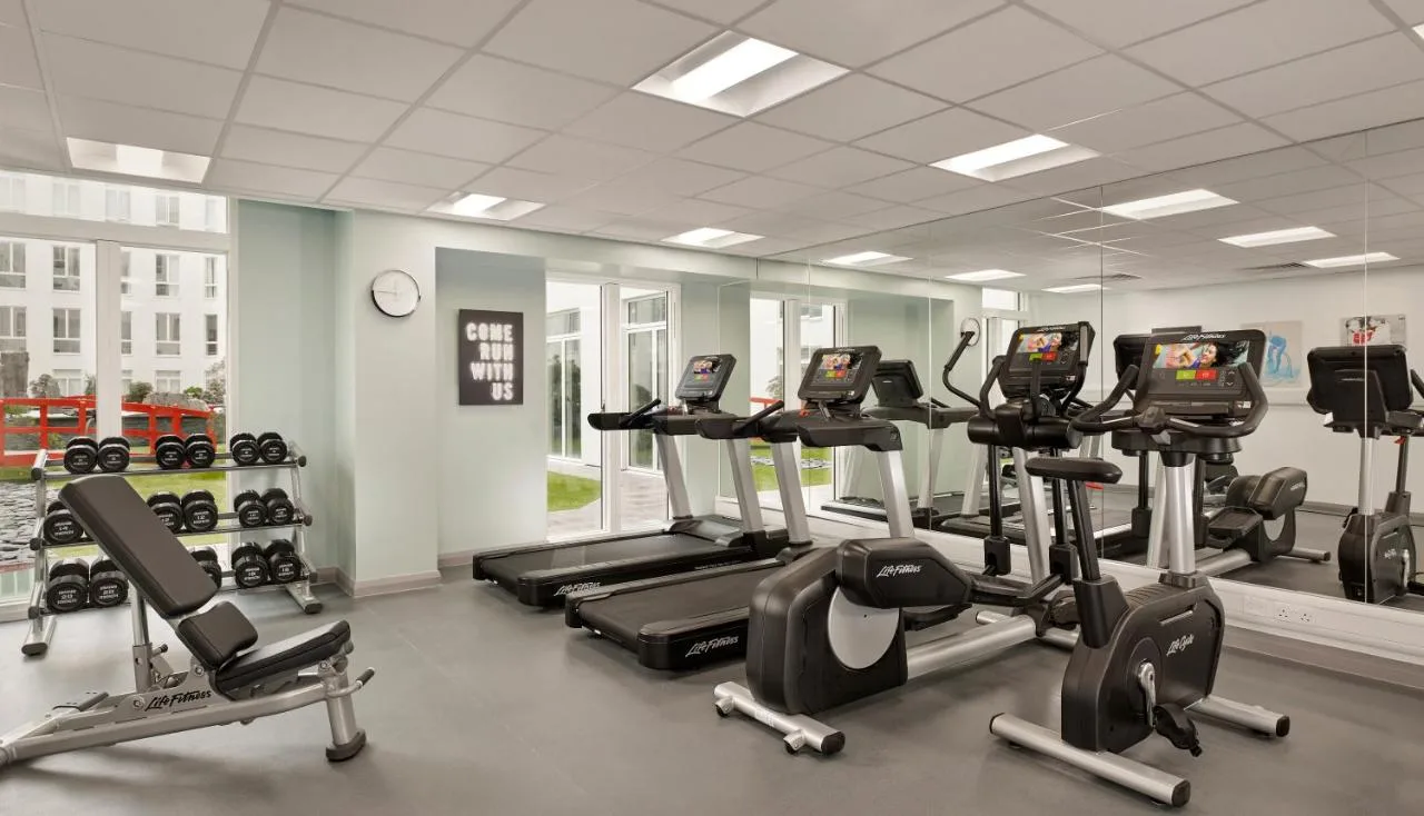 a gym with a row of treadmills and exercise machines