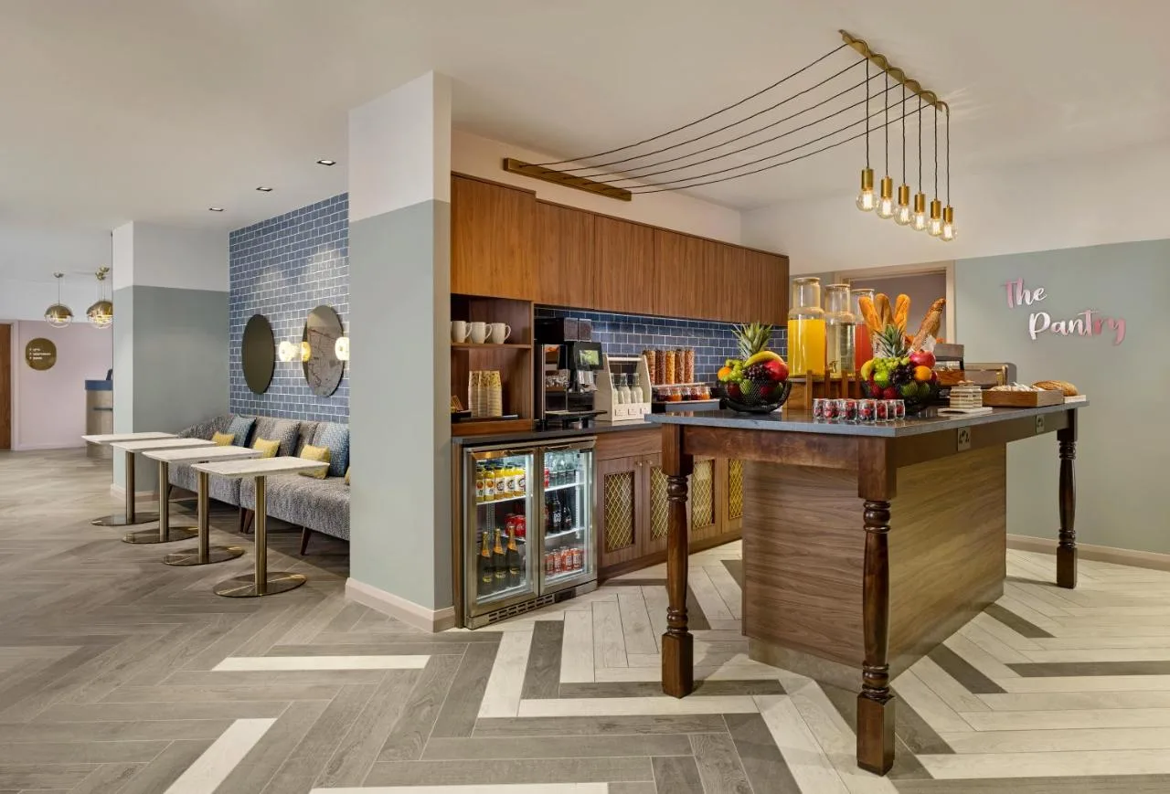 a restaurant with a bar in a room with chairs at Citadines Islington