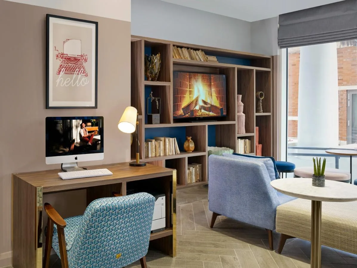 a living room with a tv, desk and chairs at Citadines Islington London